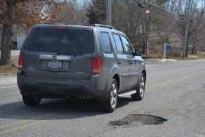 A car swerves to avoid a pothole on Mount Sinai-Coram Road in Mount Sinai. Photo by Barbara Donlon