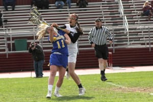 Jamie Fischer, a Comsewogue midfielder, collides with a Deer Park player on the first draw of a game the Warriors' won 17-7 on April 27. Fischer scored a hat trick in the match. Photo by Desirée Keegan