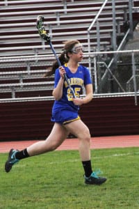 Comsewogue's Julia Tuohy carries the ball into Deer Park's zone on the road to the Warriors' 17-7 win on April 27. Photo by Desirée Keegan