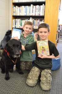 Brothers, from left, Liam and Daniel Regan, with Mac at the North Shore Public Library. Photo by Sue Wahlert