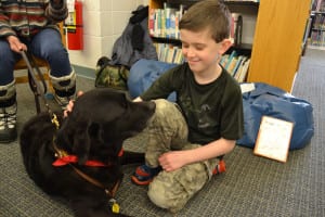 Daniel Regan visits with Mac at the North Shore Public Library. Photo by Sue Wahlert