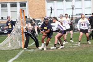 Shoreham-Wading River’s Jesse Arline pulls the ball out and away from the crease to try to get an open look at the net in the Wildcats’ 12-4 loss at Sayville Friday. Photo by Desirée Keegan
