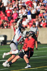 Mount Sinai senior midfielder Zack Rudolf maintains possession of the ball as he cuts inside past a Manhasset player in the Mustangs’ 7-6 Class B Long Island championship loss at Stony Brook University on May 30. Photo by Bill Landon