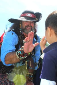 A pirate gives a young boy a high-five after a treasure hunt during Port Jefferson's annual Boater's Maritime Festival on June 7, 2015. Photo by Bob Savage