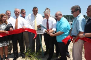 Officials cut a ribbon to mark the reopening of the beach at Centerport Yacht Club. Photo by Rohma Abbas