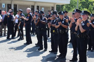 Officers applaud Police Inspector Edward Brady during his farewell at the 2nd Precinct on Friday, July 17. Photo by Victoria Espinoza.