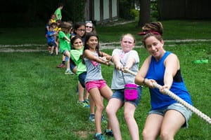 Camp counselors and young campers yank on a rope in a tug-of-war exhibition at Benner’s Farm. Photo by Michaela Pawluk