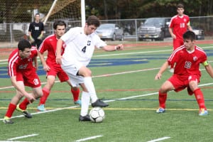 Smithtown West's Nathan Biondi maintains possession as East Islip defenders swarm around him. Photo by Desirée Keegan