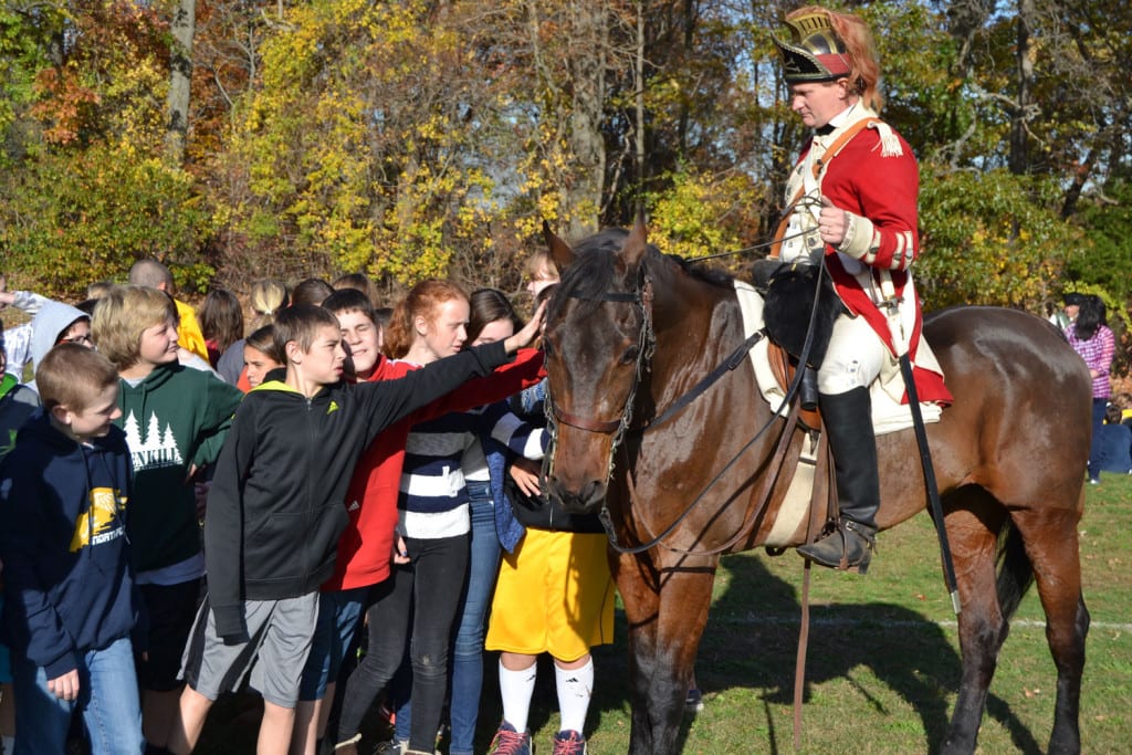 Students pet re-enactor Frank Bedford's horse on Nov. 9