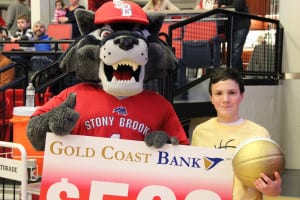 Ethan Agro poses for a photo with Wolfie after banking his three-point shot during the Stony Brook University men's basketball game, winning $500 from Gold Coast Bank. Photo from SBU