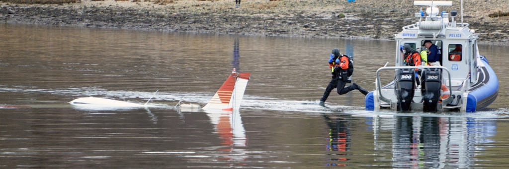 Divers with the Suffolk County Police Department plunge into Setauket Harbor after a plane crash-landed on Feb. 20. Photo from Margo Arceri