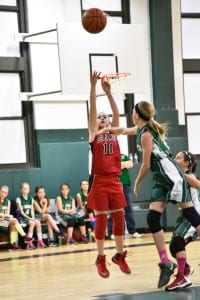 Center Catie Edson scores to help her St. James’ fifth-grade CYO basketball team take its first lead in the fourth quarter. Photo by Bruce Larrabee