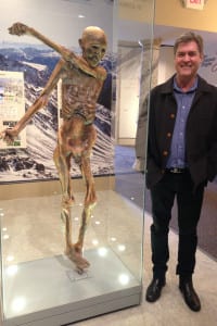 David Micklos, executive director of the DNA Learning Center, stands next to the only authorized replica of Ötzi outside of the South Tyrol Museum in Italy. Photo by Daniel Dunaief
