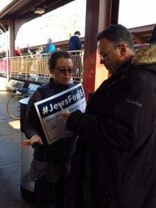 A protestor speaks to a passenger at the Huntington train station. Photo from Michael Pauker 