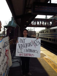 A protestor raises a sign on the platform. Photo from Michael Pauker 
