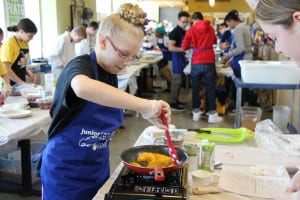 A member of The Four Toasters from Sagamore Middle School cooks canned peaches at the fourth annual Junior Iron Chef Competition. Photo by Giselle Barkley