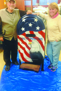 Maureen Pouder stands to the right of the American Legion Arthur H. Clune Post 1533’s new flag depository mailbox she painted. Photo from the Town of Brookhaven