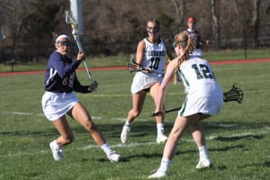 Miller Place's Alyssa Parrella hugs the sideline while maintaining possession against Julia Clementi and Falyn Dwyer and crossing the ball into Harborfields’ zone. Photo by Desirée Keegan