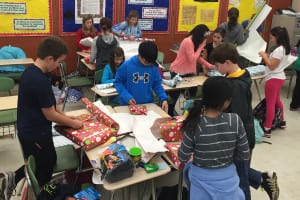 The Mount Sinai Community Service and Outreach Club wraps presents raised for and donated to local families. Photo from Lindsey Ferraro