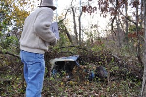 Jack Smith takes a closer look at a wrecked car on the Gentlemen's Driving Park track around the time he first discovered the forgotten historical spot. Photo by Elana Glowatz