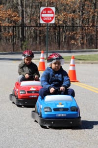 Children practice traffic safety in Safety Town’s small cars. Photo by Giselle Barkley