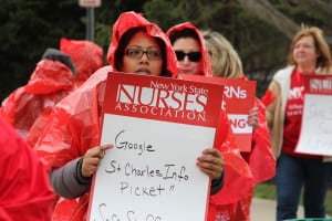 Nurses and their supporters picket outside St. Charles Hospital on April 8, calling for higher staffing levels and encouraging passing drivers to honk in solidarity. Photo by Giselle Barkley