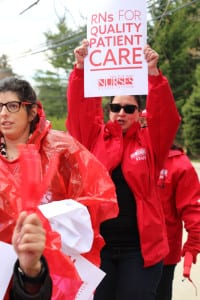 Nurses and their supporters picket outside St. Charles Hospital on April 8, calling for higher staffing levels and encouraging passing drivers to honk in solidarity. Photo by Giselle Barkley