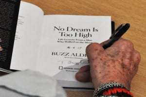 Buzz Aldrin signs a copy of "No Dream Is Too High" at the Book Revue on April 5. Photo by Elana Glowatz