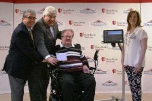 John Cincar, center, accepts the eye-tracking iPad device in Stony Brook thanks to a donation from The Bowlers to Veterans Link. Photo from Long Island State Veterans Home