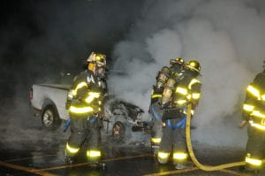 Firefighters inspect the pickup truck after the fire is put out. Photo by Steve Silverman.