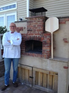 Maurizio Del Poeta in front of the brick oven he built in the backyard of his Mount Sinai home. Photo by Chiara Luberto