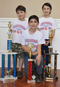 The three Prestia boys smile with their chess trophies. Photo from Rosanna Prestia