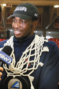 Jameel Warney carries a net around his neck after the Stony Brook University men's basketball team won the America East championship. Photo from SBU