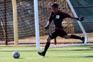 Aaron Siegel sends the ball into play in a game against Ward Melville last season. File photo by Desirée Keegan