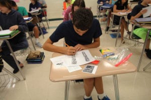 A Rocky Point Middle School student draws symbols associated with 9/11 during class. Photo by Victoria Espinoza