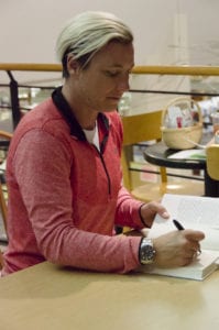 Abby Wambach signs copies of her books at the Book Revue on Monday night. Photo by Rebecca Anzel