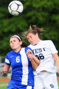 entereach’s Emily Tirado and Smithtown West’s Jillian Meaney leap up to head the ball. Photo by Bill Landon