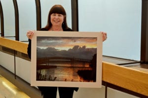 Diane Towers with her photograph, ‘Light My Way’. Photo courtesy of Mather Hospital