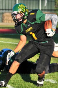 John Corpac carries the ball across the gridiron in a game last season. File photo by Bill Landon