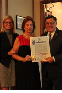 Brookhaven Town Councilwoman Jane Bonner, left, and Brookhaven Town Supervisor Ed Romaine, right, present Mount Sinai Civic Association President Ann Becker with a proclamation. Photo by Desirée Keegan