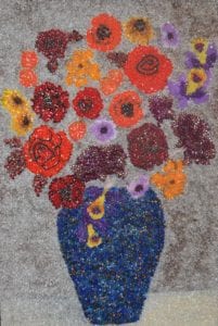 ‘Beckoning Blooms,’ beads on canvas, by Marie G., Jean C. and Shirley D., residents of North Hills Bristal Assisted Living, is one of 33 works on view. Image from LIM