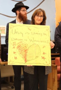 A local rabbi holds up another sign encouraging unity. Photo by Victoria Espinoza
