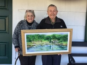 Barbara and Les Wuerfl of Stony Brook hold their new painting "Welcome to the Party" by Irene Ruddock, which they won at the Setauket Artists' Exhibition raffle. 